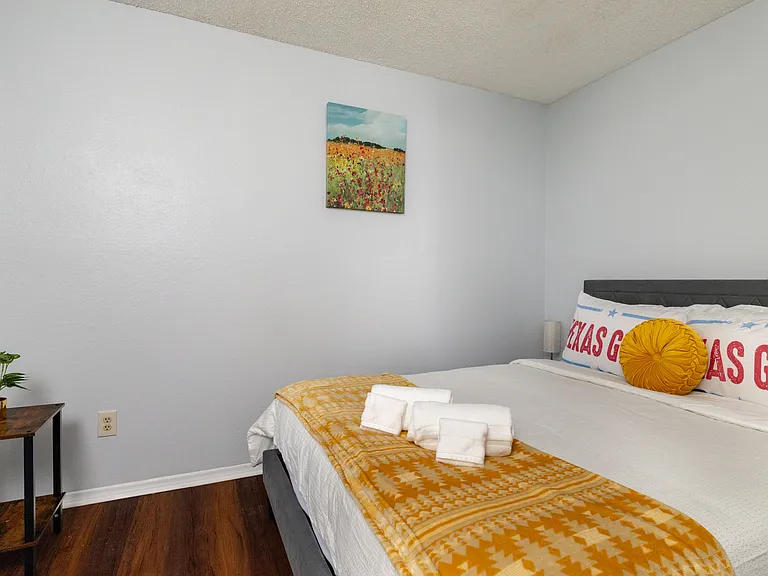Queen bed with vibrant yellow accents and Texas-inspired decor.