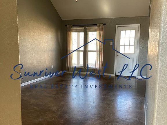 Living area with vaulted ceiling & polished concrete floors.
