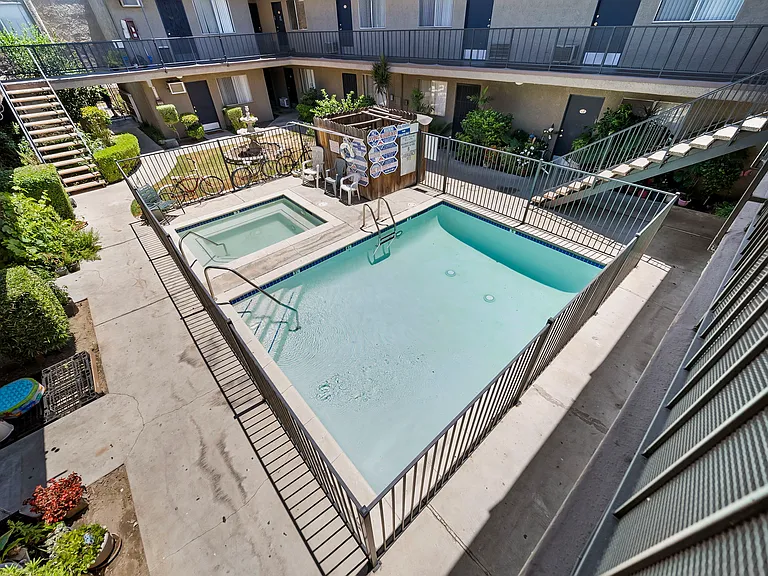 Refreshing community pool set within a well-maintained courtyard, offering a relaxing space to unwind.
