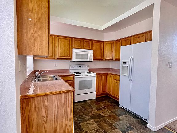 Kitchen with refrigerator, electric stove and dishwasher.