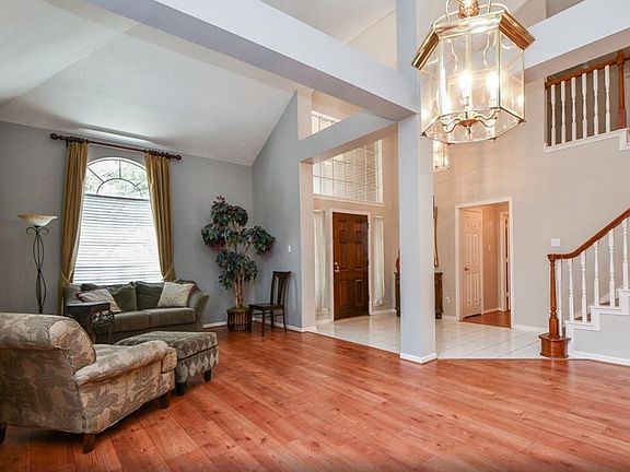 Grand foyer entry with open formal living room and wood floors throughout.