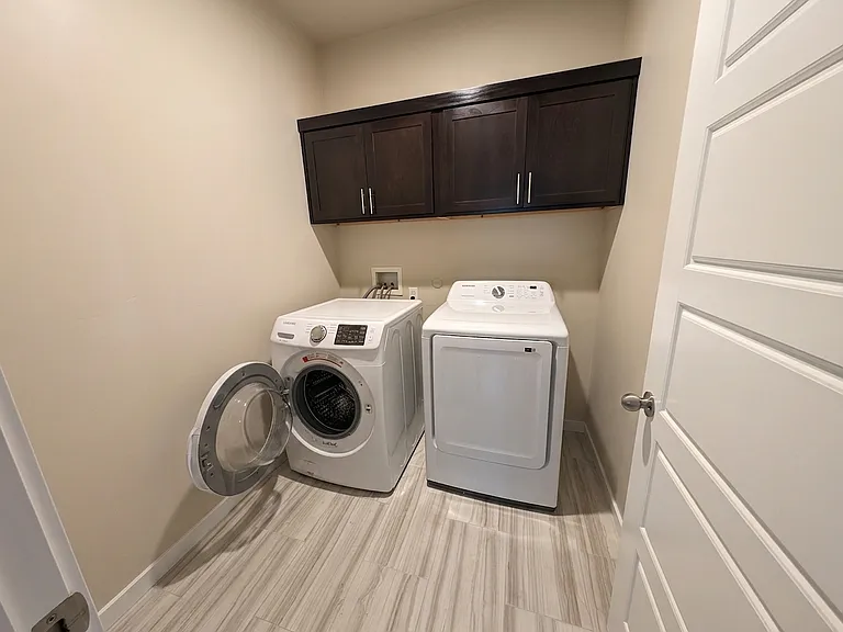 Laundry room has cabinetry and washer/dryer is included.