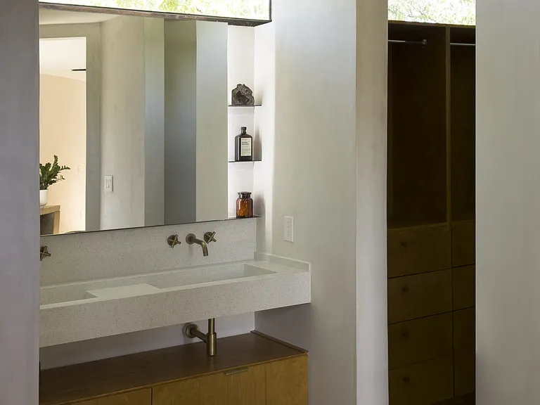 Double sink bath adored with white quartz and steel. Walk-in closet comes with a laundry chute.