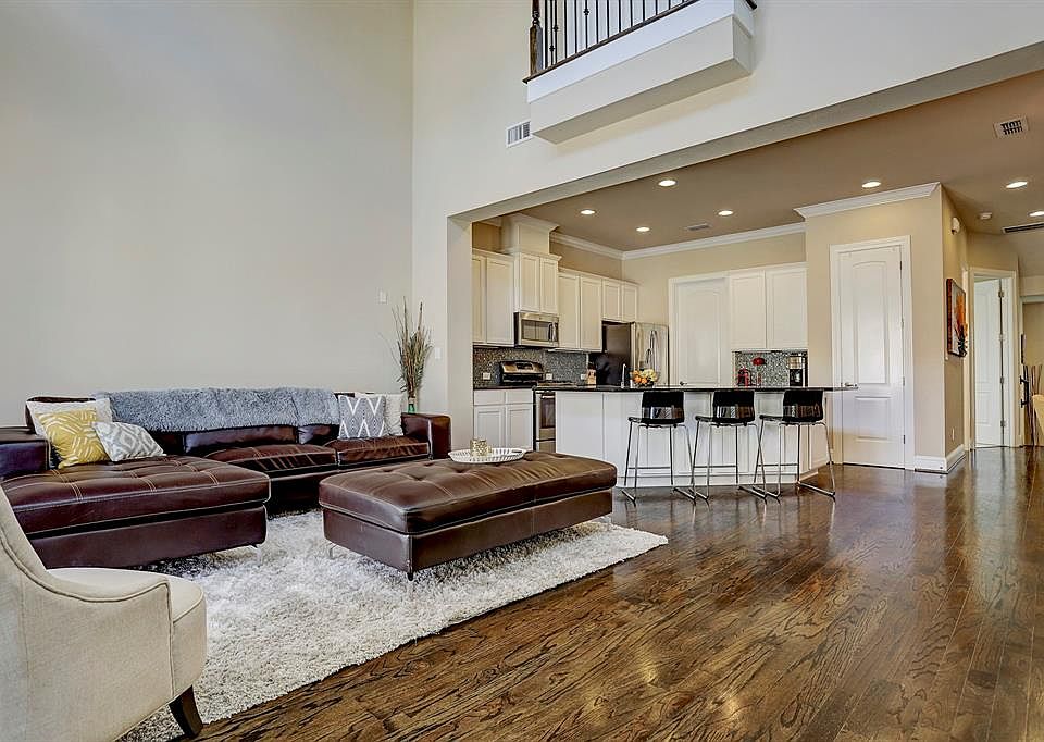 Look at this living room with a two-story ceiling which allows natural light to pour into these rooms! Very spacious living room which opens to the island kitchen and the dining room as well. Great layout for entertaining! Wonderful hardwood floors, 