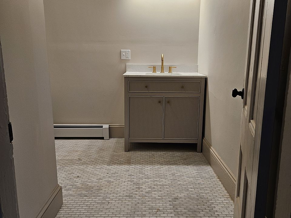 Spacious main bathroom features gleaming tile floors and a walk-in shower