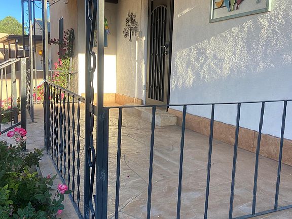Front porch is flagstone with wrought iron railings, exterior fan light, and security screen door.