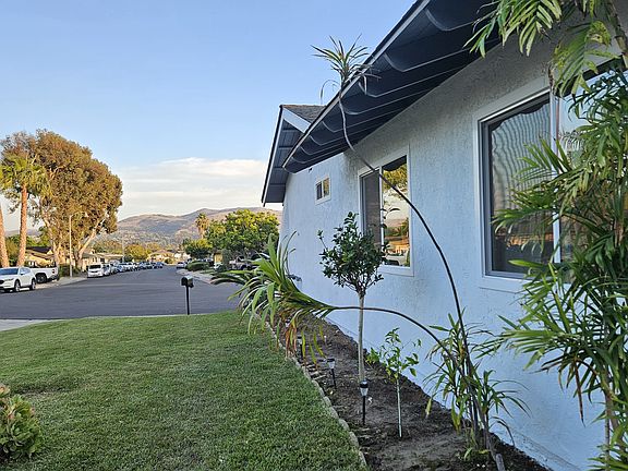 Side yard of home showing primary bedroom, middle bedroom and guest bathroom windows