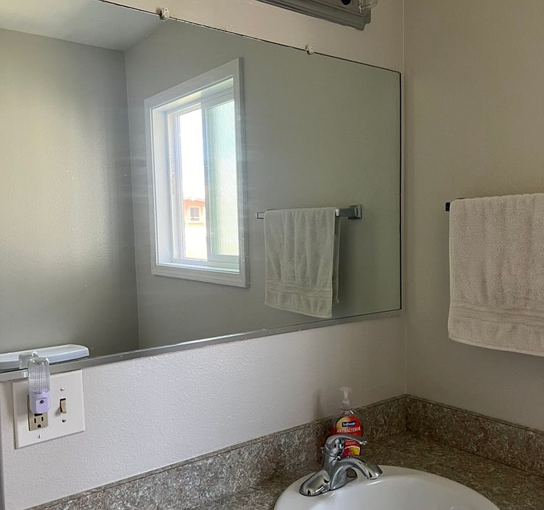 Vanity and toilet in one area of the bathroom, tub and extra linen storage in the room next to it. (Extra large bathroom)