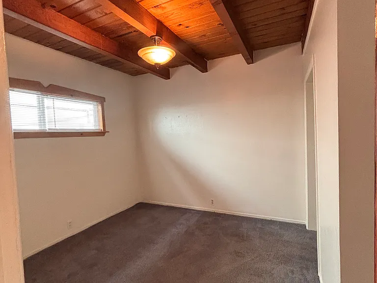 Bedroom in back is spacious. Window high up for maximum light from outside and privacy inside.