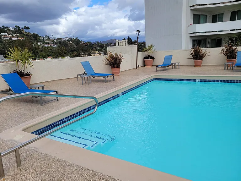 Apartments in Hollywood, CA - Pool, Patio with Lounge Chairs and Tables with view of Mountain