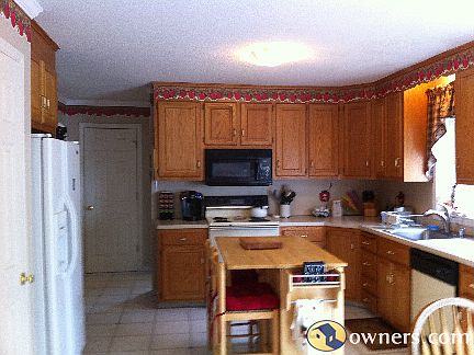 Bright open kitchen with newer fridge and microwave
