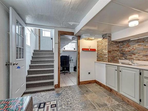 Kitchen includes extensive tile work, new flat-top stove (not pictured) and full-sized refrigerator (not pictured). Lighting and pull-out faucet have been upgraded since the photo.