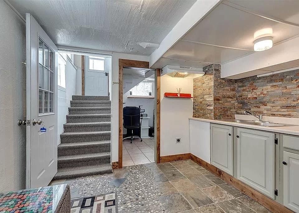 Kitchen includes extensive tile work, new flat-top stove (not pictured) and full-sized refrigerator (not pictured). Lighting and pull-out faucet have been upgraded since the photo.