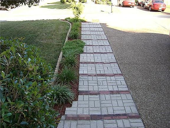 custom brick work along both sides of aggregate driveway