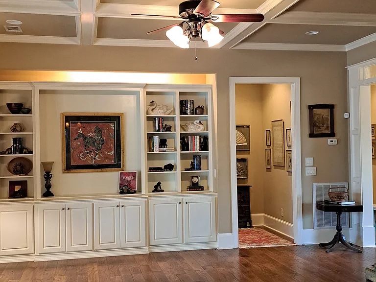 Great room with coffered ceiling, built in bookcases and cabinets