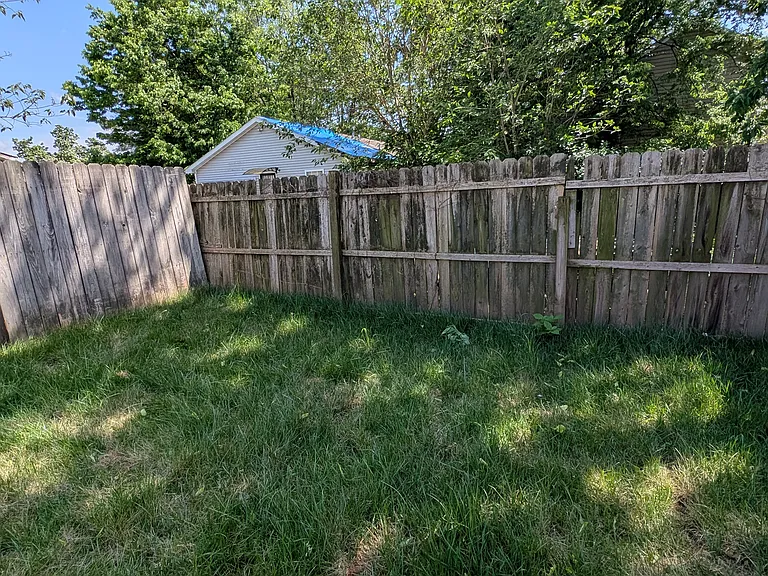 Fenced-in yard with mature trees providing shade and privacy_your own green retreat right at home.