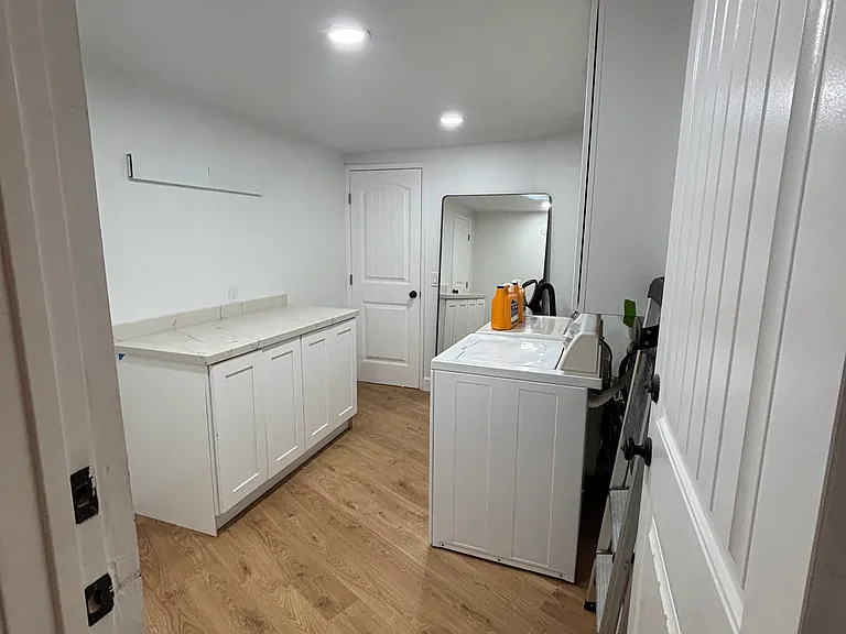 Large laundry room with extra storage, folding counter, and fold out unit for hang drying clothes