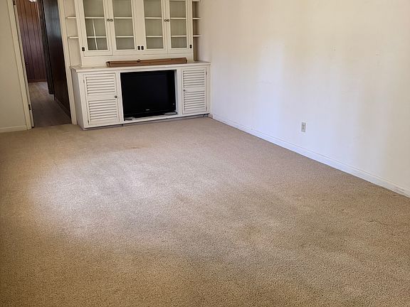 Living room from the front door entrance. Large built in entertainment center.