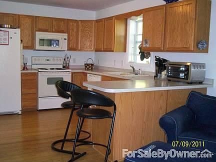 Kitchen with adjacent Sitting Area : Bamboo Flooring, spacious counter tops, wooden cabinets, all ap
