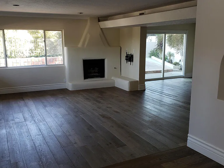 View when you enter the home and oversee the living room with fireplace and built in display shelf on right.