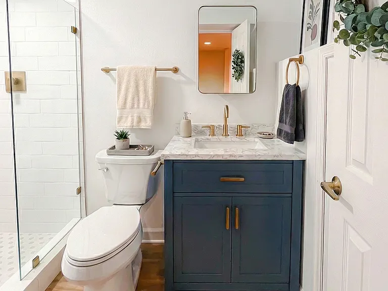 Bathroom view with updated vanity, toilet, towel storage, and modern finishes.