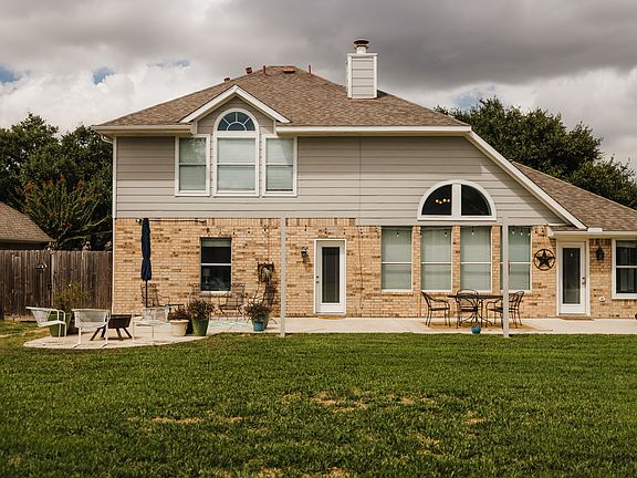 Large fenced backyard with patio and entertaining lighting.