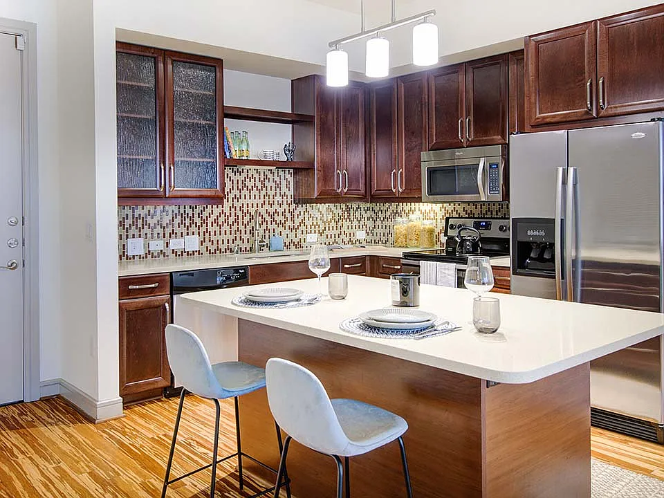 Griffis Uptown apartment kitchen with quartz countertops and stainless steel appliances.