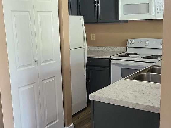 New kitchen with newly added laundry room and over-stove microwave.