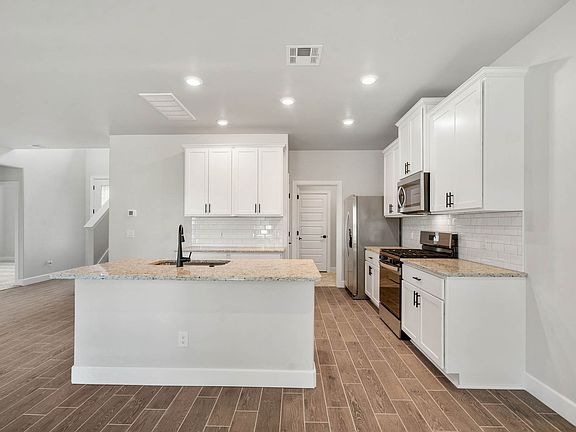 The upgraded kitchen has a large kitchen island with granite countertops.