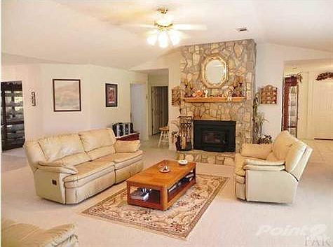 Another view of the great room with High Vaulted ceilings and lighted ceiling fan.