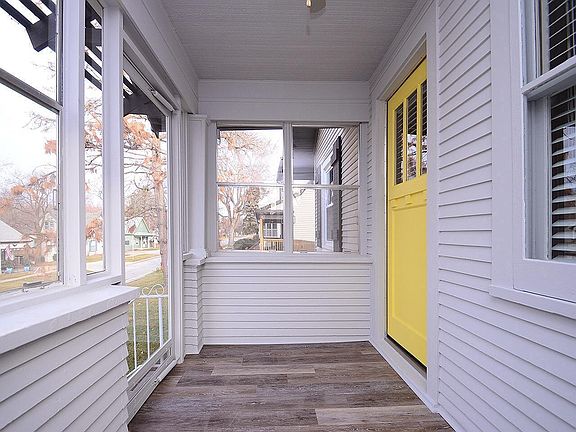 Enclosed front porch with laminate wood floor.