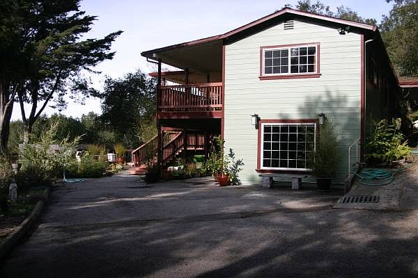 View from the large parking pad, even bigger than shown and devoted to downstairs apartment. Large window is the bedroom.