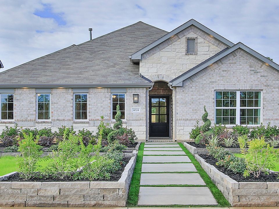 Luxurious stone facade with pristine landscaping in Colony at Pinehurst, Texas.