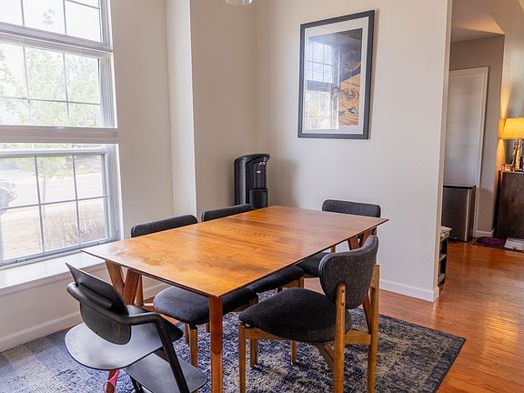 Light-filled dining space flowing seamlessly from the kitchen, featuring a large window and hardwood floors_set within a home thoughtfully refreshed with interior paint just two years ago.