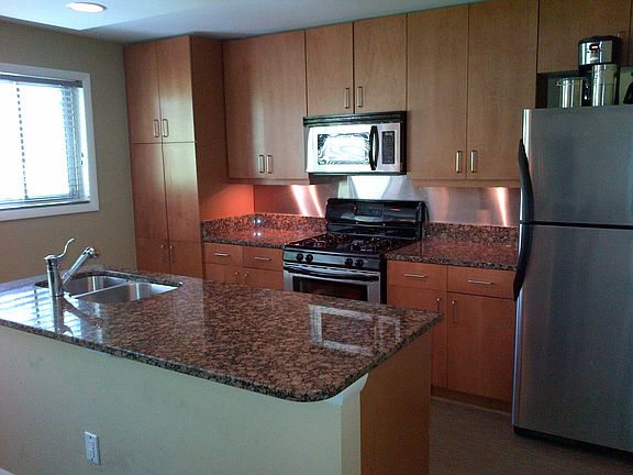renovated kitchen with granite counter and stainless appliances