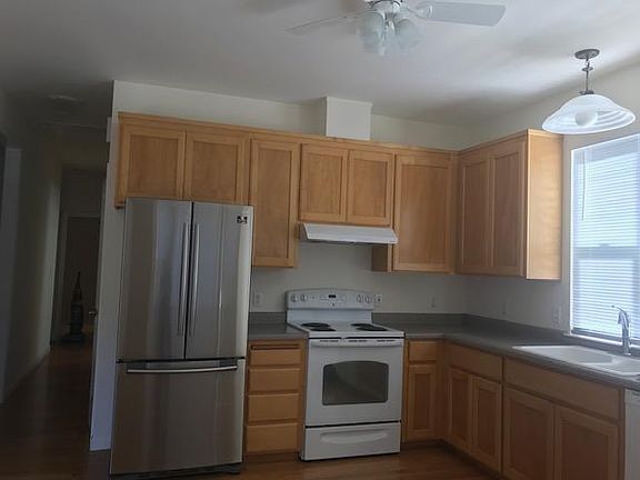 Kitchen with an abundance of cabinet space, bay window, ceiling fan