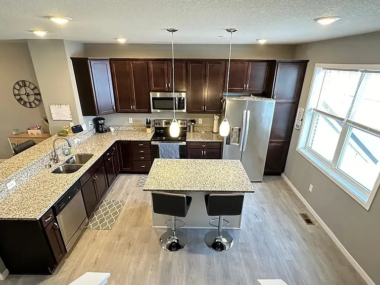 Step into modern living with LS Capital Group's stunning kitchen, featuring sleek cabinetry, stainless steel appliances, and an inviting island. This sleek design makes meal prep a joy. Explore your future home today!