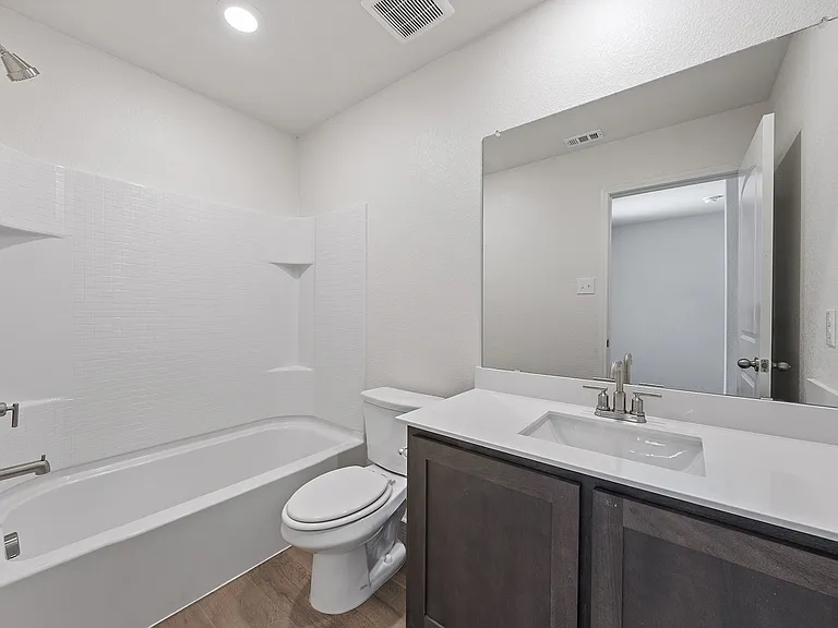 The secondary bathroom of the Sabine has a large vanity and shower-tub combo.