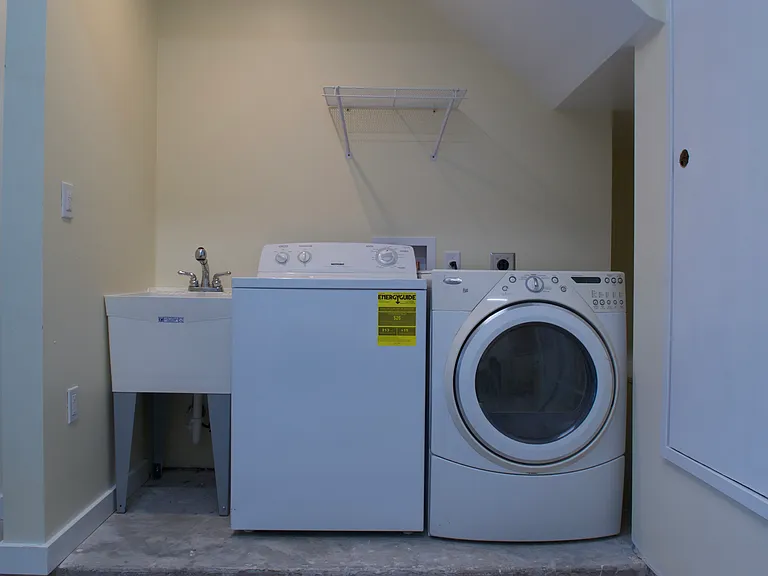 Full size laundry appliances and a big utility sink in the separate laundry room.