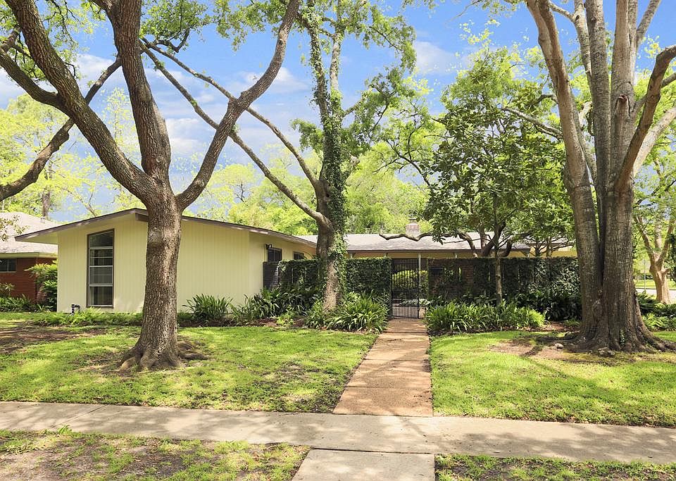 Situated on an 11,067 sq ft lot in the heart of Meyerland, this 1955 model home by architect Robert 