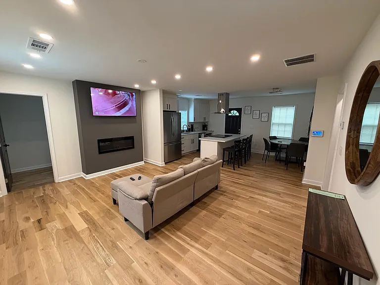 Open-concept living area flows into a kitchen with island seating, stainless appliances, and a dedicated dining nook.