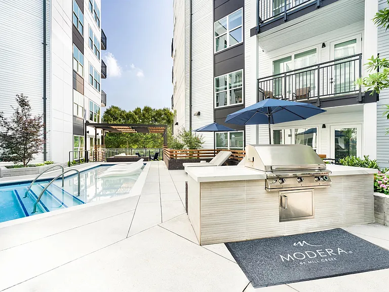 Poolside grilling station with shaded seating, in-water loungers, and gathering areas designed for easy entertaining in Atlanta's Westside neighborhood.
