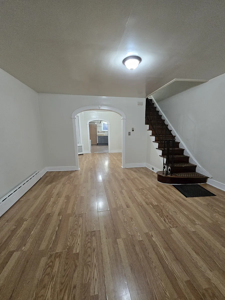 Photo 2 of 23 - 2213 McKean St - Philadelphia, PA Spacious living area with open layout and staircase access - 2213 McKean St