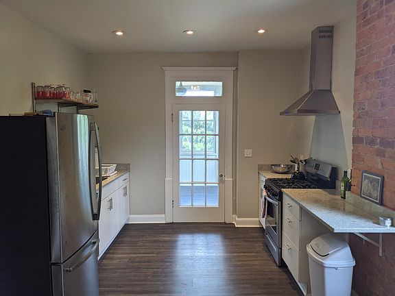 Newly renovated kitchen with stainless steel appliances and granite countertops. Door opens to the sun room.