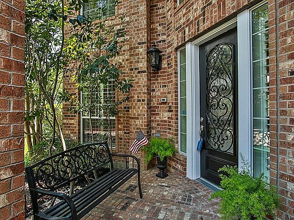 As you approach the front of the home, you will notice the glass front door with decorative wrought iron.