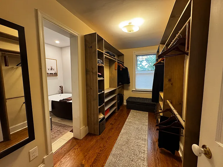 Large walk-in closet of primary bedroom en-suite with access to both ensuite bath and hallway.