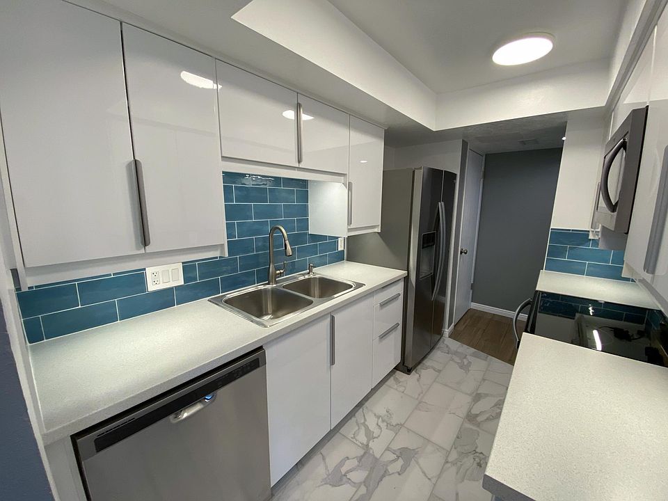New kitchen with soft-close cabinets and task lighting. Counter depth fridge with ice and water. Dishwasher and garbage disposal. Large pantry at the far end.