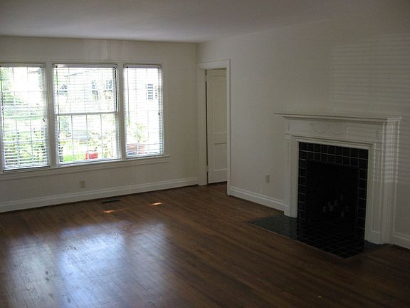 Large formal living room with lots of sunlight, fireplace, and hardwood floors