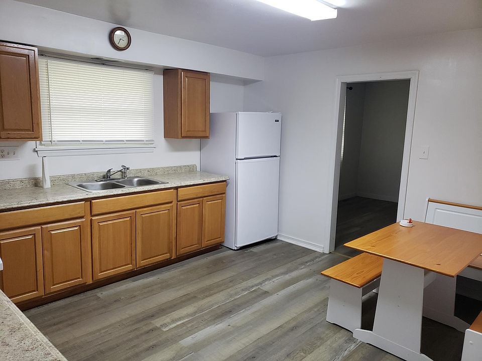 Kitchen with new vinyl flooring, cabinets, countertop, stove and refrig.