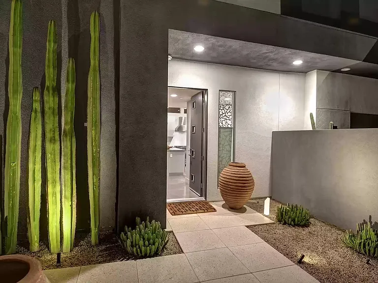 The front entry at night with landscape lighting.